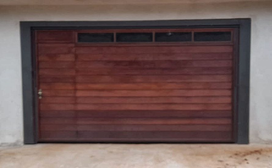 Portão de garagem de madeira com visor de vidro